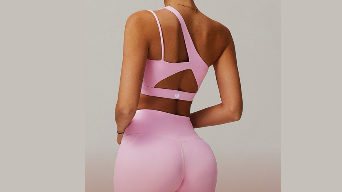 Person wearing a pink sports bra and leggings set on a neutral background