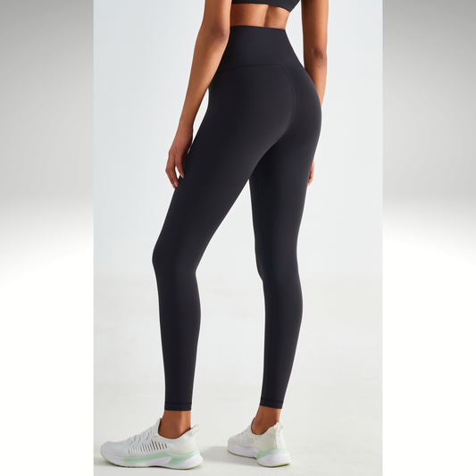 Person wearing black leggings on a light gray background